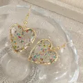 Boucles d'oreilles cœur résine fleurs séchées transparentes – 3